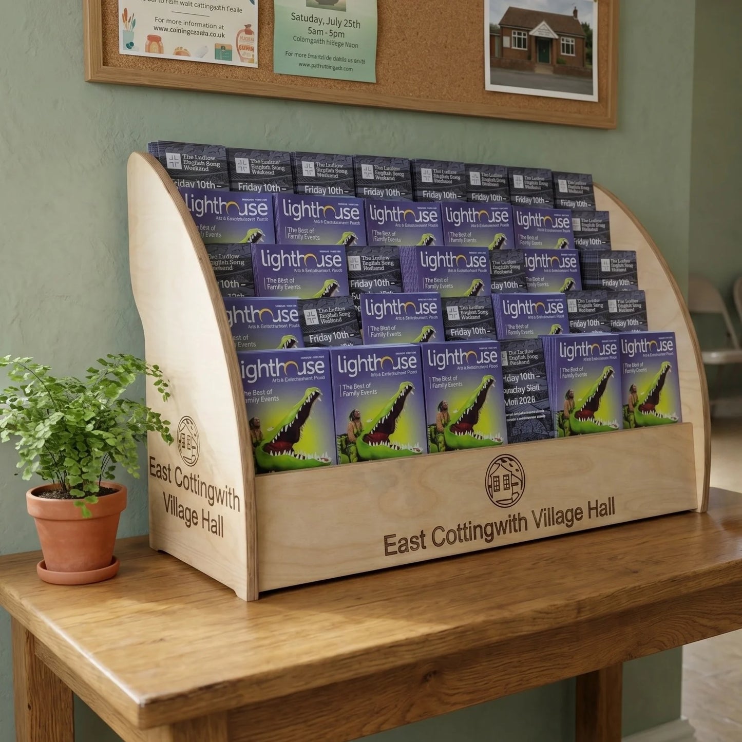 Wooden counter leaflet dispenser shown in village hall lobby setting with custom engraving example